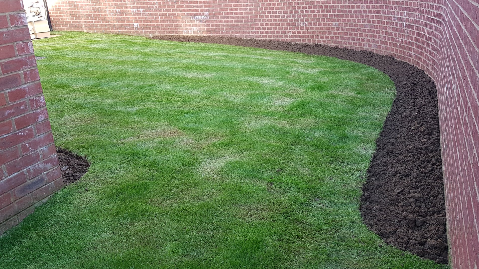 A lawn edged and a new border dug over ready for planting.